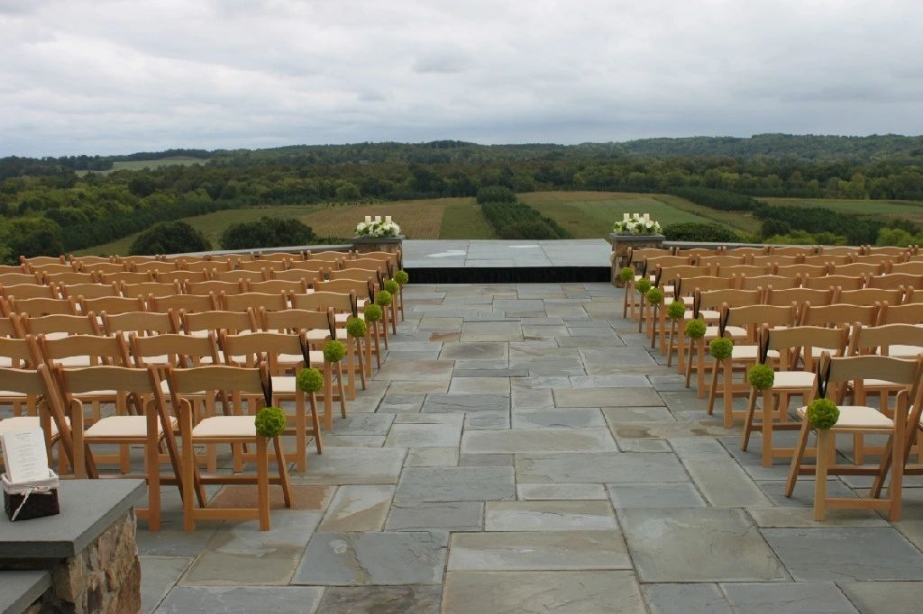 Outdoor wedding ceremony on stone terrace with countryside view