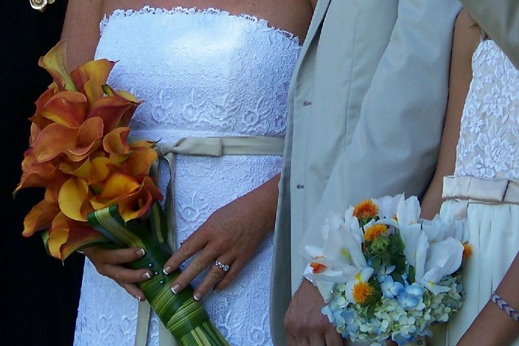 Bride and groom wedding hands with orchid bouquet
